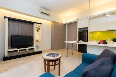 a living room with a blue couch and a tv at SIgnature Residence - Desa Sri Hartamas - Studio in Kuala Lumpur