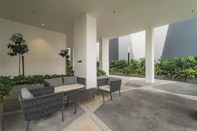 a patio with a couch and chairs and plants at Quill Residences by DX in Kuala Lumpur