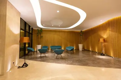 a waiting room with blue chairs and a ceiling at Sunway Velocity Signature in Kuala Lumpur