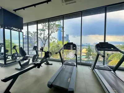 a gym with treadmills and ellipticals in a room with windows at KL Cheras at The Continew 5 pax in Kuala Lumpur