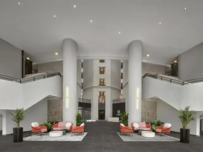 a large lobby with orange chairs and a building at The Atrium at Jalan Ampang by OKBnB - Modern 2Bedroom, 10 mins to Pavilion KL in Kuala Lumpur