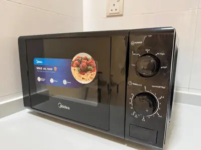 a microwave with a bowl of fruit in it at Peaceful 3BR 2B with Pool 10pax Wangsa Maju near Wangsa Walk in Kuala Lumpur