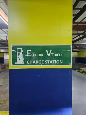 a sign for an electric vehicle charge station on a wall at NEW Bangsar Trade Centre KL Mid Valley LRT Bangsar in Kuala Lumpur