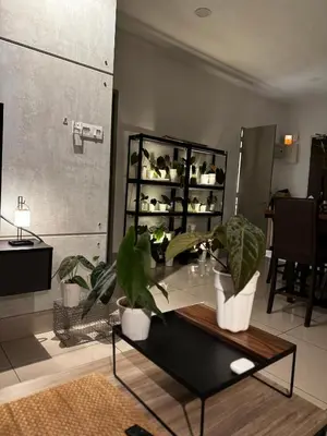 a living room with potted plants on a table at One Residences in Kuala Lumpur