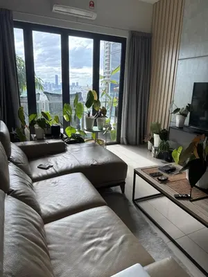 a living room with couches and a large window at One Residences in Kuala Lumpur