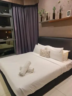 a large white bed with a shoe on it at ROBERTSON RESIDENCE south SUITES IN KUALA LUMPUR in Kuala Lumpur