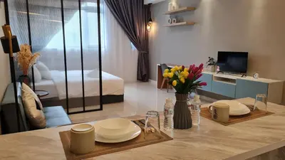 a living room with a table with plates and flowers at Chambers Suites KL By 969 in Kuala Lumpur