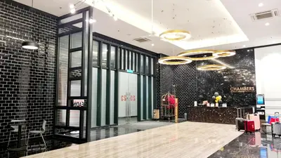 a lobby of a store with a woman standing next to a counter at Chambers Suites KL By 969 in Kuala Lumpur