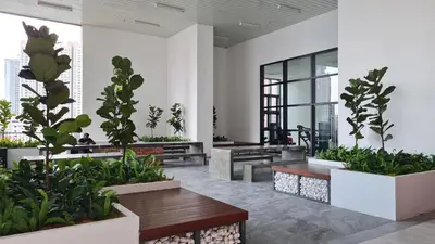 a lobby with benches and plants in a building at Chambers Suites KL By 969 in Kuala Lumpur