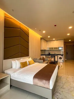 a bedroom with a large bed and a kitchen at Hartamas Societe by MYAbnb in Kuala Lumpur