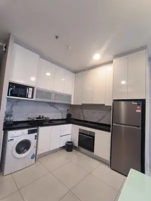 a kitchen with white cabinets and a washer at Hartamas Societe by MYAbnb in Kuala Lumpur