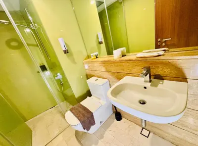 a bathroom with a sink and a toilet and a shower at Vortex Suites Yonder Twin Tower in Kuala Lumpur