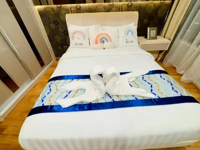 two stuffed animals on a bed with a rainbow at Vortex Suites Yonder Twin Tower in Kuala Lumpur