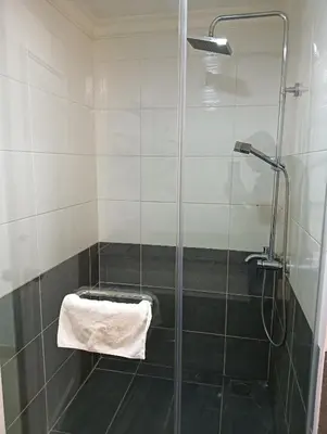 a shower with a glass door with a towel at Eastern Suites Times Square KL in Kuala Lumpur