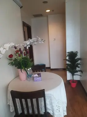 a table with a white table cloth and flowers on it at Eastern Suites Times Square KL in Kuala Lumpur
