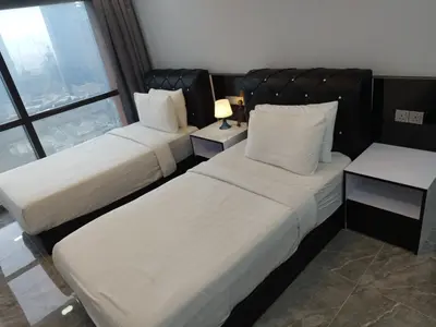 a hotel room with two beds and a window at Eastern Suites Times Square KL in Kuala Lumpur