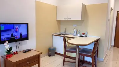 a small kitchen with a small table and a television at 103 Hotel in Kuala Lumpur