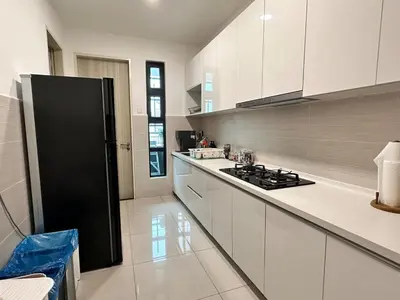 a kitchen with white cabinets and a black refrigerator at Home away from home near KLCC in Kuala Lumpur