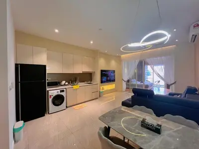 a living room with a blue couch and a kitchen at Lovely & Comfy Quill Residence, Near Monorail& Quill City Mall in Kuala Lumpur