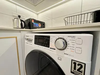 a white washer and dryer in a kitchen at Axon Bukit Bintang Lovely 1BR Suite with KL View in Kuala Lumpur