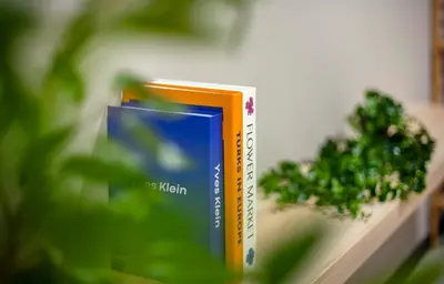 a book sitting on a shelf next to a plant at Backpackers Studio at Neu Suites Ampang in Kuala Lumpur