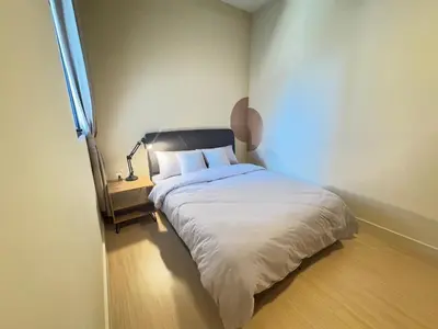 a bedroom with a bed and a lamp on a wooden floor at KL TRX view # IKEA MRT # 2 BED 2BATH # Continew KL in Kuala Lumpur