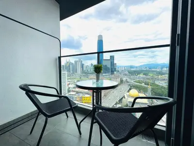 a table and chairs on a balcony with a view of a city at KL TRX view # IKEA MRT # 2 BED 2BATH # Continew KL in Kuala Lumpur