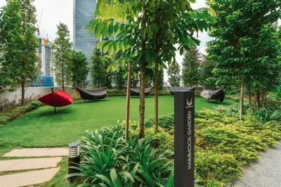 a garden with hammocks and a green yard with trees at Agile Bukit Bintang by KAN's in Kuala Lumpur