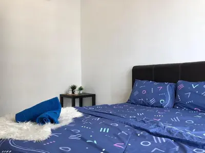 a bed with a blue comforter and blue pillows at Ampang 4-6 pax in Ampang Point in Ampang
