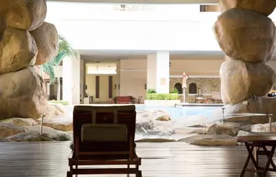 a resort lobby with a pool and a chair at Windsor Tower Sri Hartamas by Plush in Kuala Lumpur