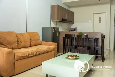 a living room with a couch and a table at Windsor Tower Sri Hartamas by Plush in Kuala Lumpur
