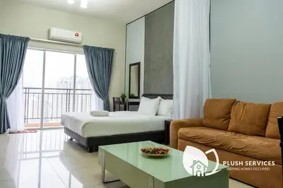 a hotel room with a bed and a couch at Windsor Tower Sri Hartamas by Plush in Kuala Lumpur