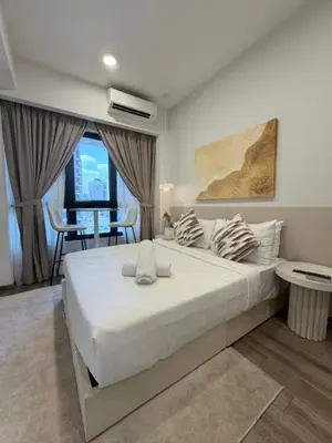 a bedroom with a large white bed and a table at Agile Residence TRX By Alltech Homes in Kuala Lumpur
