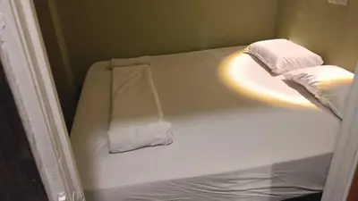 a small bed with two pillows on top of it at Health Homestay KL in Kuala Lumpur