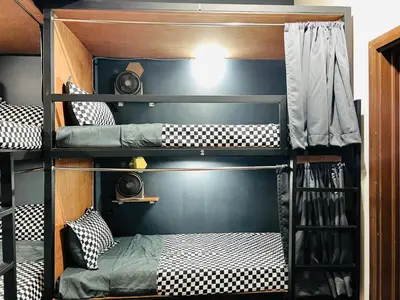 three bunk beds in a room with a bed at Empire Hostel Regalia in Kuala Lumpur