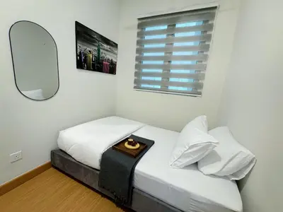 a small bedroom with a bed with a mirror at MH Platinum 2 COZY Fully Air-Con Suite Kuala Lumpur in Kuala Lumpur