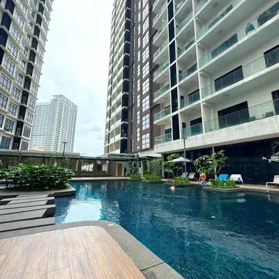 a swimming pool in the middle of two tall buildings at 188 Suites KLCC Hotel with bathtub in KL in Kuala Lumpur