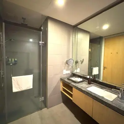a bathroom with a shower and a sink and a mirror at 188 Suites KLCC Hotel with bathtub in KL in Kuala Lumpur
