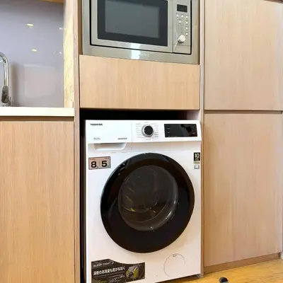 a microwave and a washing machine in a kitchen at 188 Suites KLCC Hotel with bathtub in KL in Kuala Lumpur