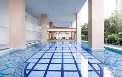 a swimming pool with a blue tile floor in a building at Gastfamilie maytower in Kuala Lumpur