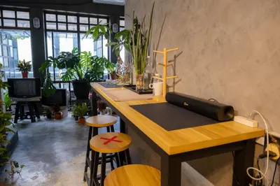 a kitchen with a bar with stools and plants at Pak Fook Hotel Chow Kit in Kuala Lumpur