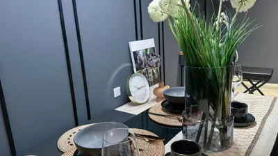 a table with a vase with flowers on it at Just Stay Axon Residence Suite Bukit Bintang in Kuala Lumpur