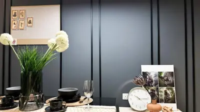 a table with a vase of flowers and a clock at Just Stay Axon Residence Suite Bukit Bintang in Kuala Lumpur