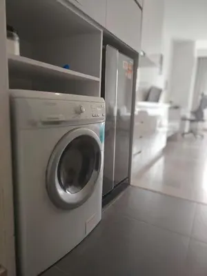 a washing machine in a kitchen with a refrigerator at 1Bukit ceylon view 118 in Kuala Lumpur