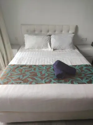 a white bed with a hat on top of it at 1Bukit ceylon view 118 in Kuala Lumpur