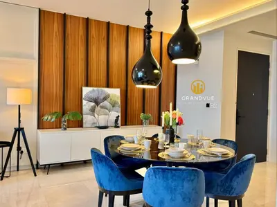 a dining room with a table and blue chairs at Luxury Tropicana The Residence SkyPool KlccView CityCenter By HeyStay Management in Kuala Lumpur