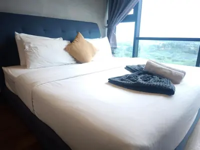 a large white bed with white sheets and pillows at 8Pax Green View next to KL118 ChinaTown n Train Station in Kuala Lumpur