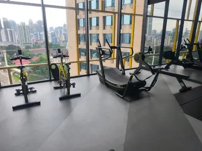 a gym with cardio equipment in a building with windows at 6pax 2BR KL118 View 5min to train Station in Kuala Lumpur