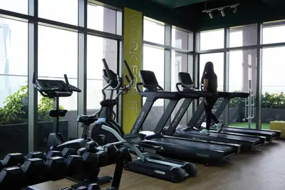 a gym with several tread machines in a room with windows at Riveria City, Kl Sentral Studio Apartment near Monorail, Infinity Pool in Kuala Lumpur