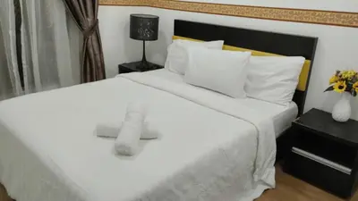 a bedroom with a large white bed with white pillows at Suasana Bukit Ceylon by Goldcrests Global in Kuala Lumpur